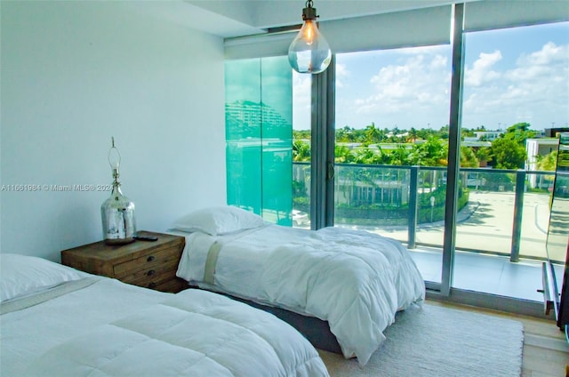 bedroom with access to exterior and hardwood / wood-style flooring