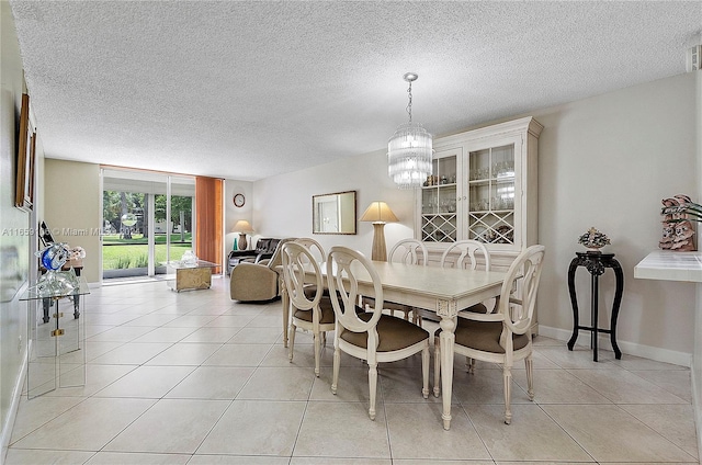 tiled dining room featuring a textured ceiling and a notable chandelier