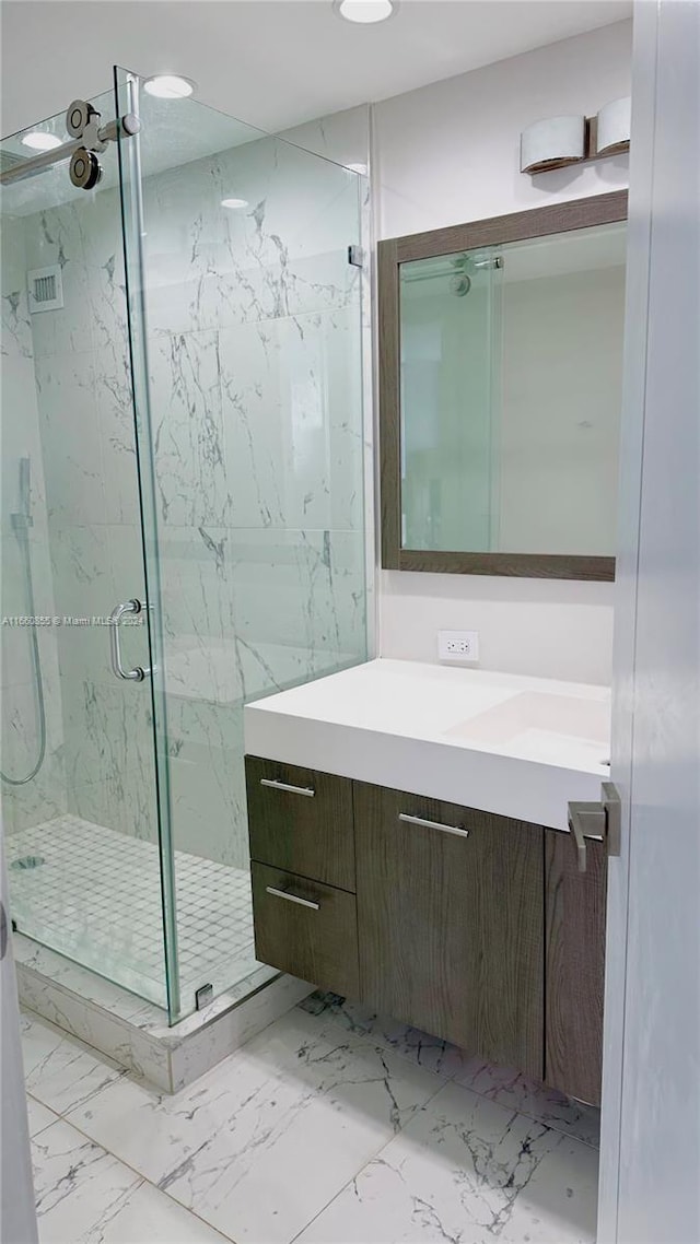 bathroom with vanity and a shower with door