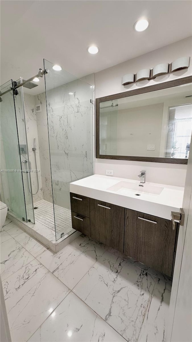 bathroom with vanity, toilet, and a shower with shower door