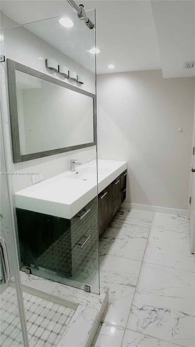 bathroom with a shower with shower door and vanity