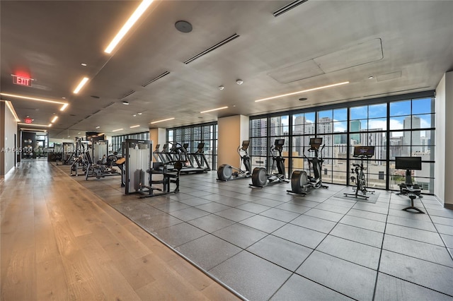 workout area with floor to ceiling windows and wood finished floors