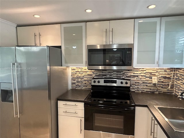 kitchen featuring decorative backsplash, white cabinetry, sink, and stainless steel appliances