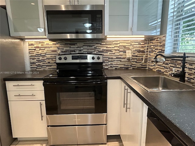 kitchen featuring white cabinets, stainless steel appliances, sink, and decorative backsplash