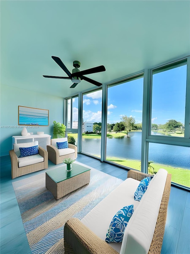 bedroom with a water view, ceiling fan, access to exterior, hardwood / wood-style floors, and floor to ceiling windows