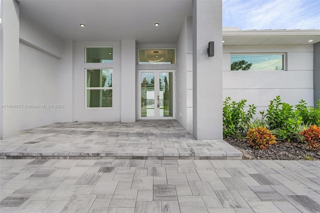 view of exterior entry with a patio area and french doors