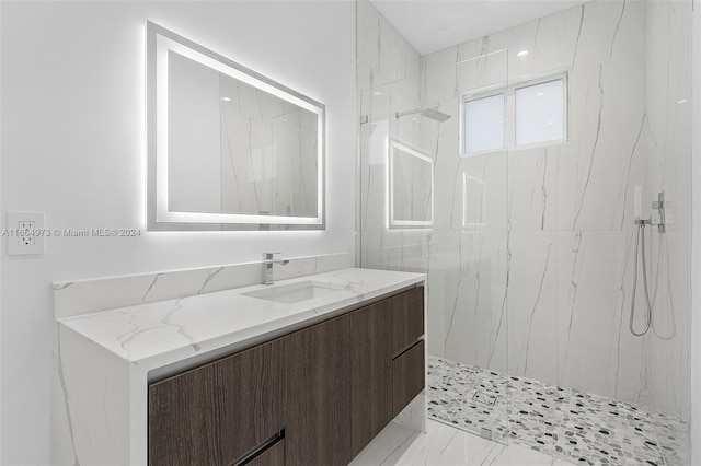 bathroom featuring tiled shower and vanity