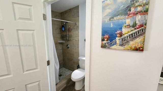 bathroom featuring toilet and tiled shower