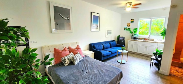 living area with sink, ceiling fan, and hardwood / wood-style flooring