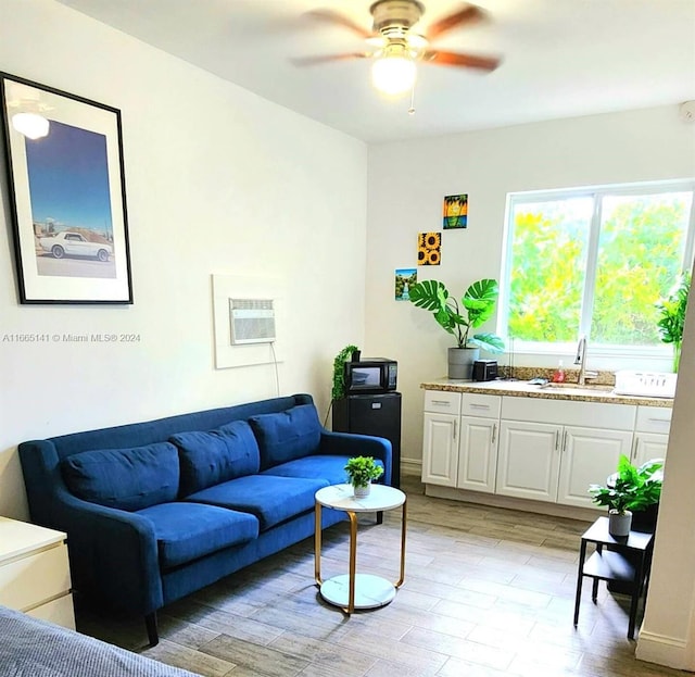 living room featuring ceiling fan, light hardwood / wood-style flooring, and sink