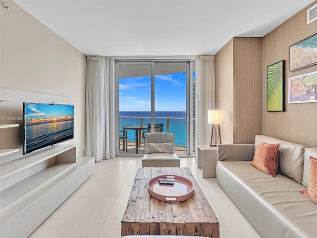 tiled living room with floor to ceiling windows and a water view