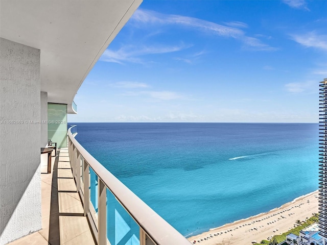 balcony featuring a beach view and a water view