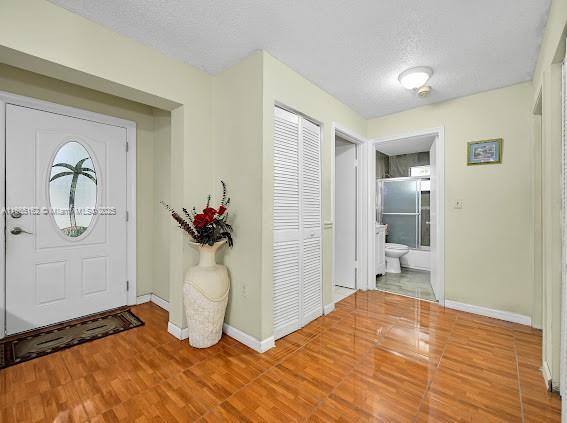 foyer entrance with hardwood / wood-style floors and a textured ceiling