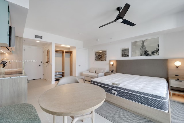 bedroom with light tile patterned floors, ceiling fan, a walk in closet, and a closet