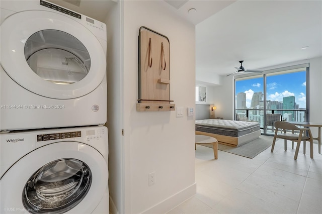 washroom with light tile patterned flooring, stacked washer and dryer, and ceiling fan