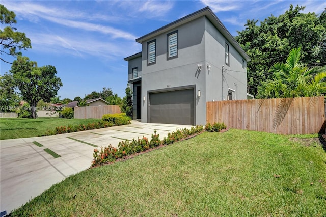 contemporary home featuring a garage and a front lawn