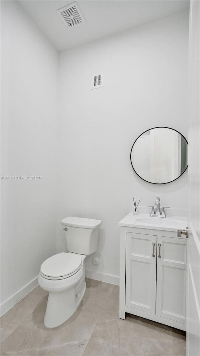 bathroom featuring vanity, tile patterned flooring, and toilet