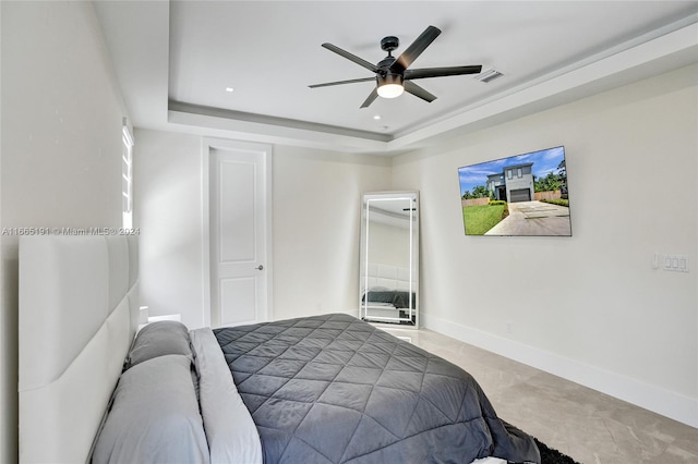 bedroom featuring ceiling fan and a tray ceiling