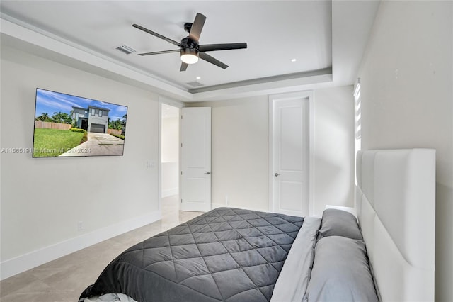 bedroom with a raised ceiling and ceiling fan