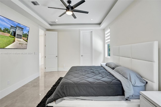 bedroom featuring ceiling fan and a raised ceiling