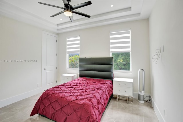 bedroom featuring ceiling fan and a tray ceiling