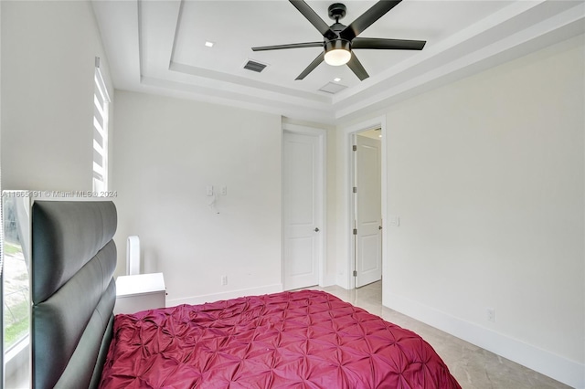 bedroom with ceiling fan and a raised ceiling