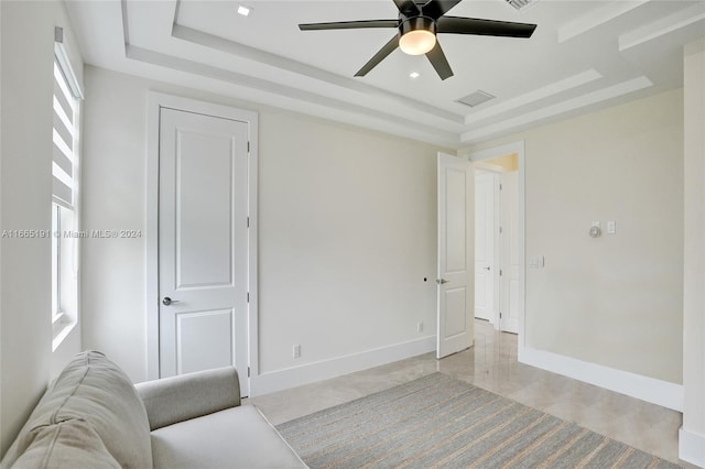 interior space featuring a tray ceiling and ceiling fan