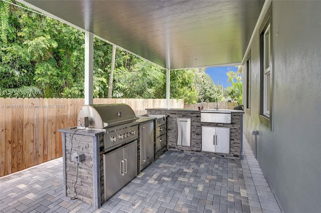 view of patio / terrace featuring an outdoor kitchen, a grill, and sink