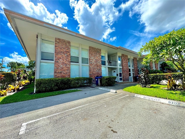 view of front facade with a balcony and a front lawn