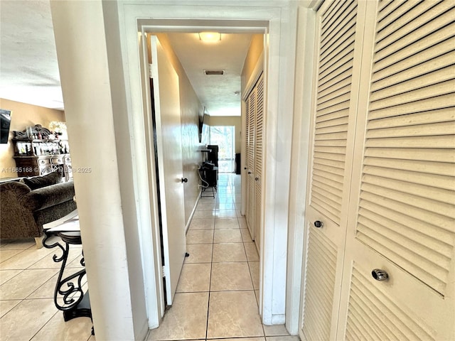 hall with light tile patterned floors