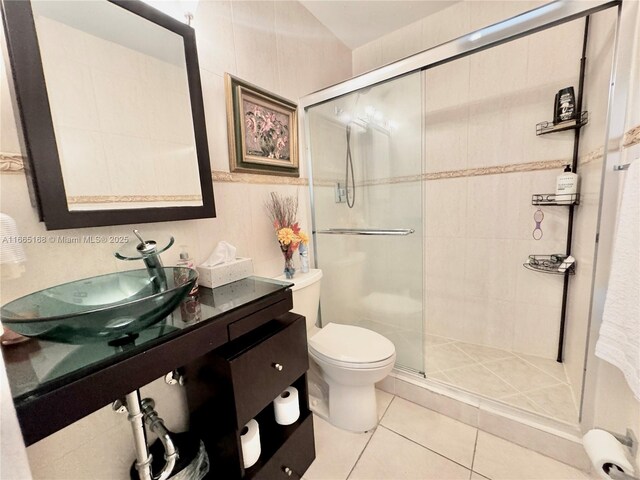 bathroom with tile walls, sink, tile patterned floors, and toilet