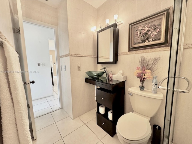 bathroom with tile patterned flooring, sink, tile walls, and toilet