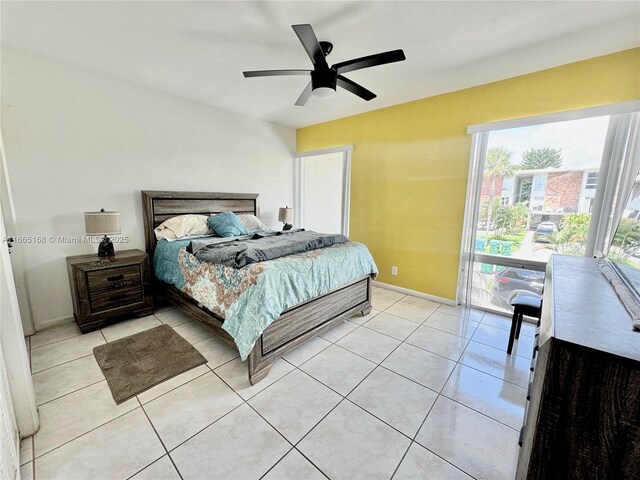 bedroom featuring light tile patterned floors, multiple closets, and ceiling fan