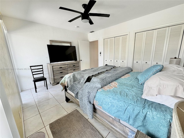 tiled bedroom with multiple closets and ceiling fan