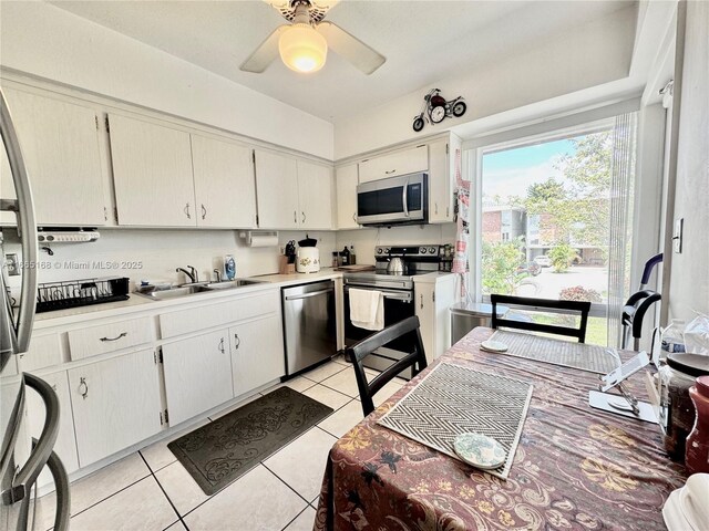 kitchen featuring white cabinetry, sink, light tile patterned flooring, and appliances with stainless steel finishes