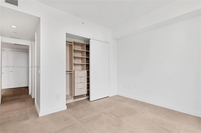 unfurnished bedroom with light tile patterned floors and a closet