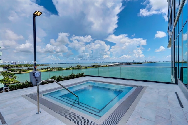 view of pool with a water view and an in ground hot tub