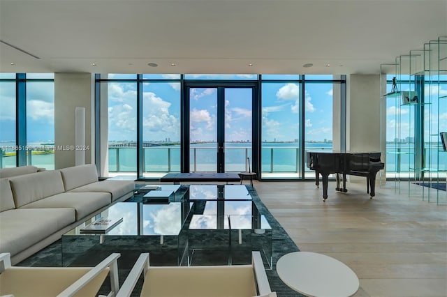 living room featuring hardwood / wood-style flooring, floor to ceiling windows, and a water view