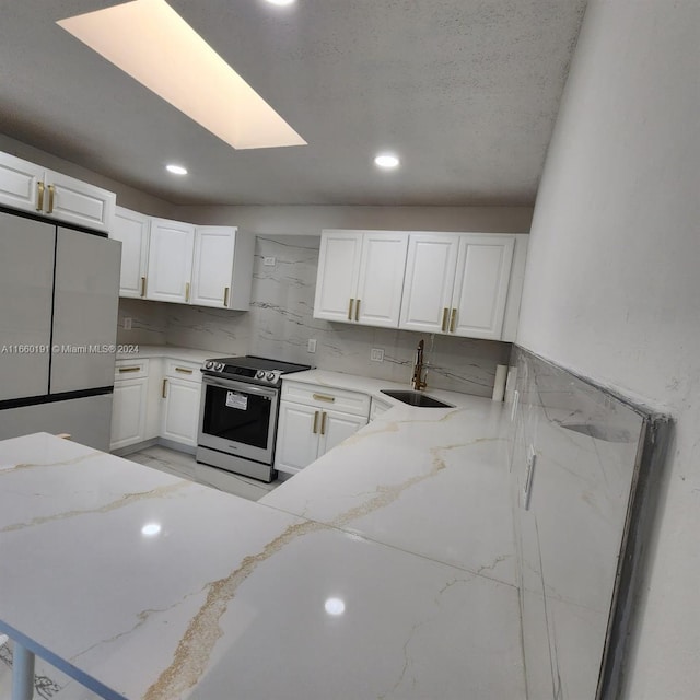 kitchen featuring white cabinets, appliances with stainless steel finishes, and sink