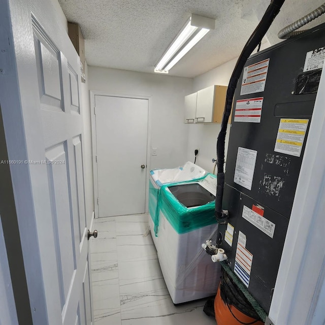 interior space with cabinets, heating unit, a textured ceiling, and electric dryer hookup