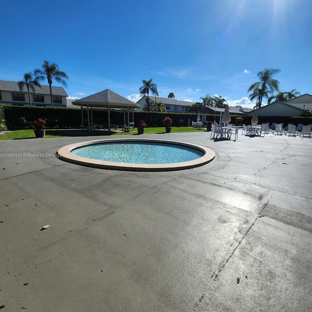 view of swimming pool with a gazebo and a yard