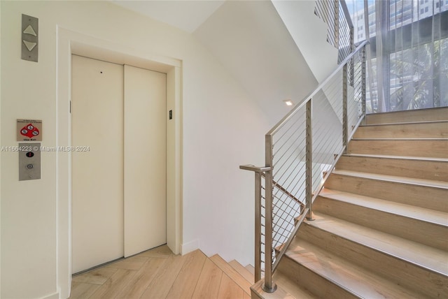 staircase with parquet flooring and elevator