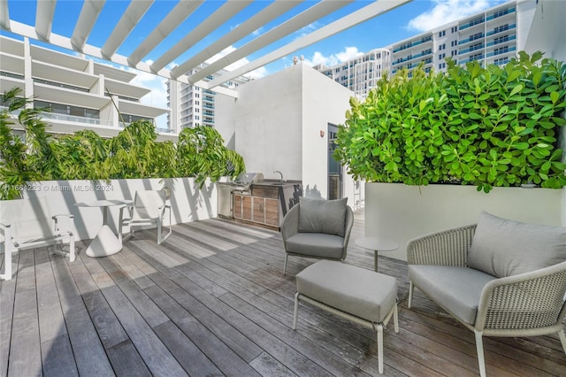 wooden terrace featuring a pergola, an outdoor living space, sink, and a grill