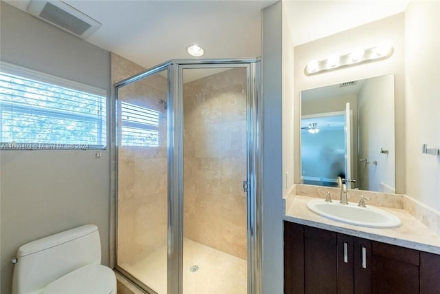 bathroom with vanity, a shower with shower door, and toilet