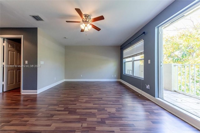 empty room featuring ceiling fan, plenty of natural light, and dark hardwood / wood-style flooring