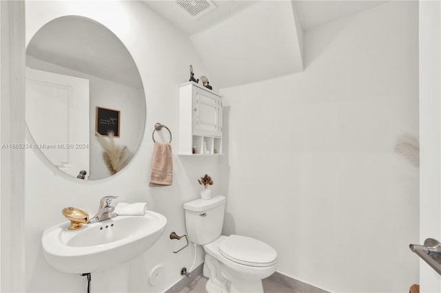 bathroom featuring vaulted ceiling, toilet, and sink