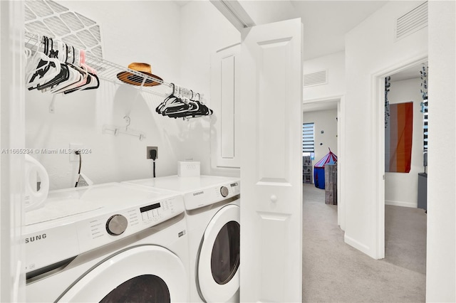 clothes washing area with light carpet and independent washer and dryer