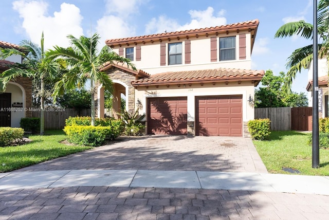 mediterranean / spanish-style house featuring a garage and a front lawn