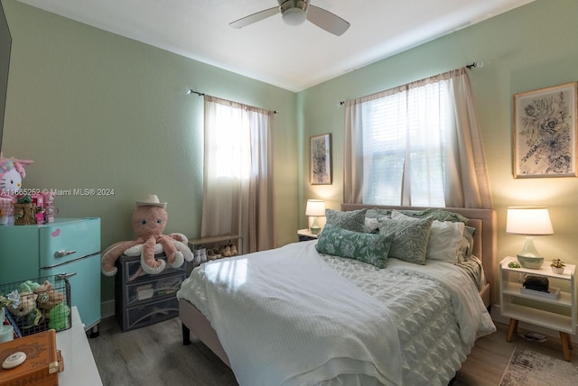 bedroom featuring multiple windows, hardwood / wood-style floors, and ceiling fan