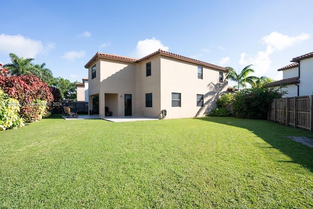 back of property featuring a patio and a yard